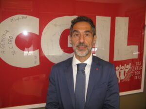 Il segretario generale della CGIL di Vicenza e provincia Giancarlo Puggioni. con bandiera Cgil 2001 genova