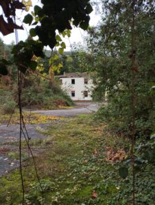 La caserma di Ghisa vista tra una sbarra e l'altra del cancello